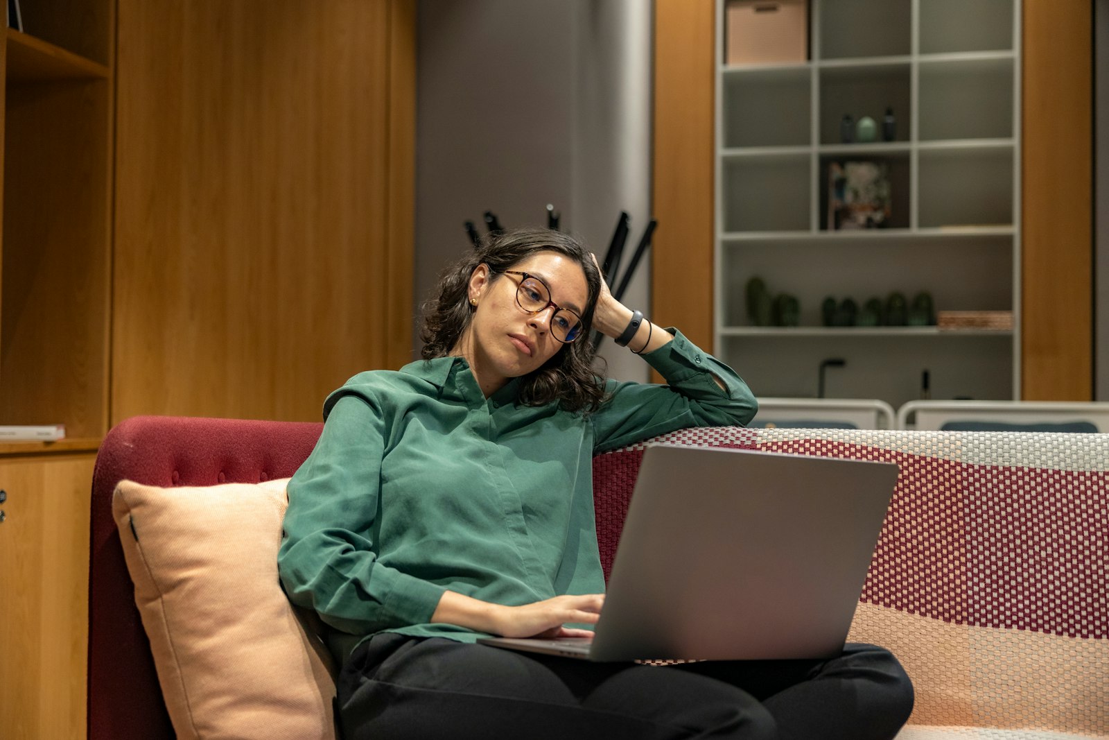 A person sitting comfortably on a couch at home with a laptop open